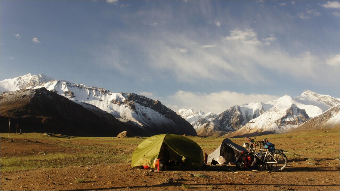 4# Loris OLMS.
Bivouac dans le Pamir.
Le soleil se lève sur notre bivouac au pied du plus haut col de la route du Pamir que nous devons franchir ce matin. La nuit nous a réservé une surprise. Elle a saupoudré les montagnes alentour d'une fine couche blanche. Contempler le résultat nous donne de bonnes énergies pour la rude journée qui nous attend.