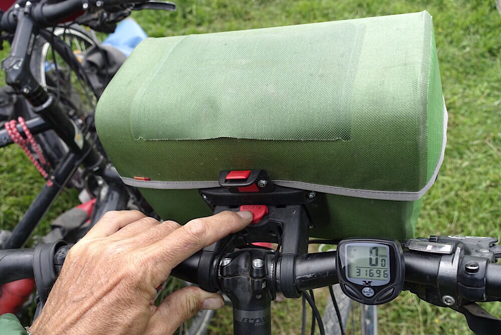 Bouton rouge pour verrouiller ou déverrouiller la sacoche sur le guidon.