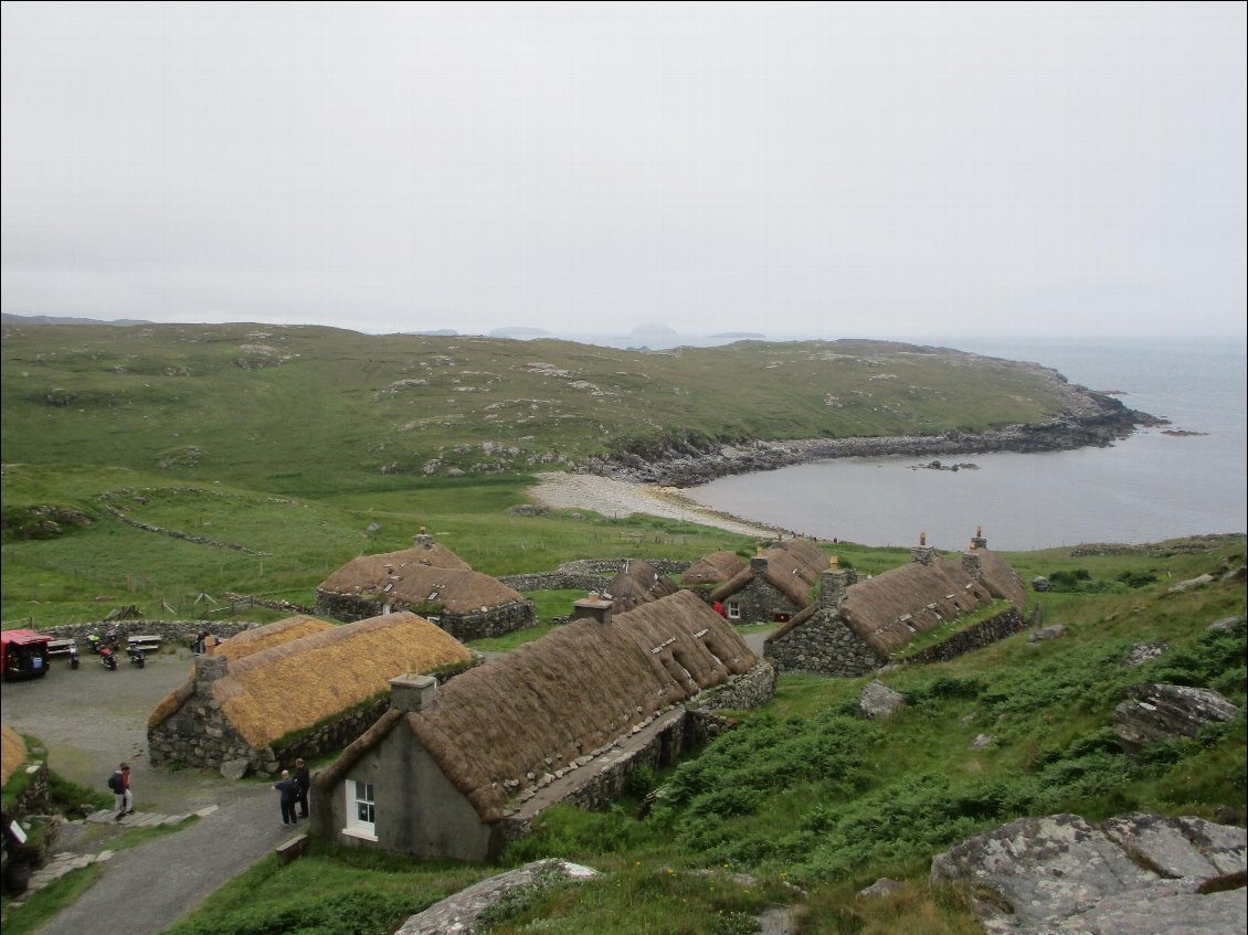 La reconstitution des blackhouses à Garenin. Pour résister au vent les toits sont lestés par des pierres. Il y a un bunkhouse parmi les maisons.