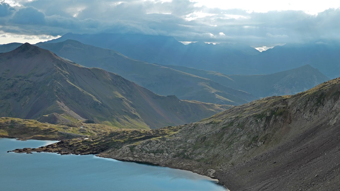 Au premier plan, un bout du lac de Urdiceto. Au dernier plan, toujours dans les nuages, le Pic Schrader.