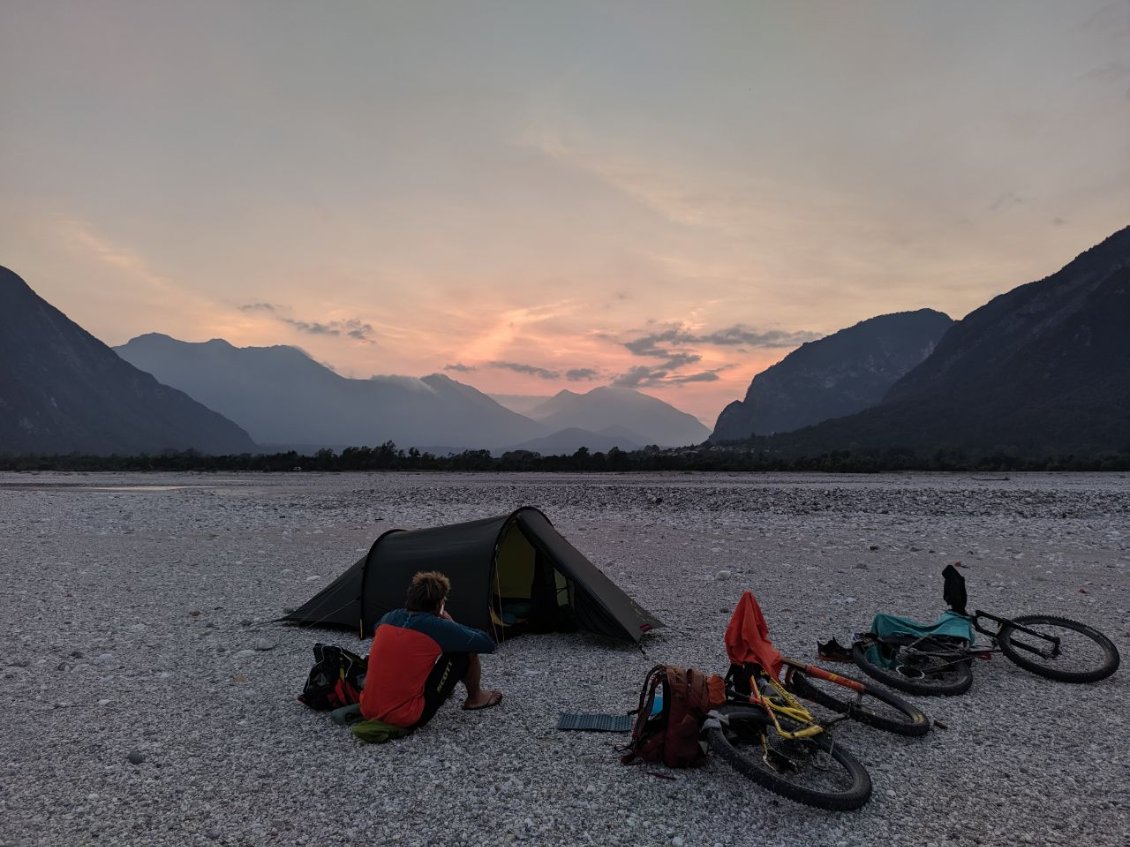 J126 - Carnia : un bivouac sur les galets après un bain dans l'eau claire puis un coucher de soleil flamboyant ! La nuit, les lumières d'Udine colore le ciel.