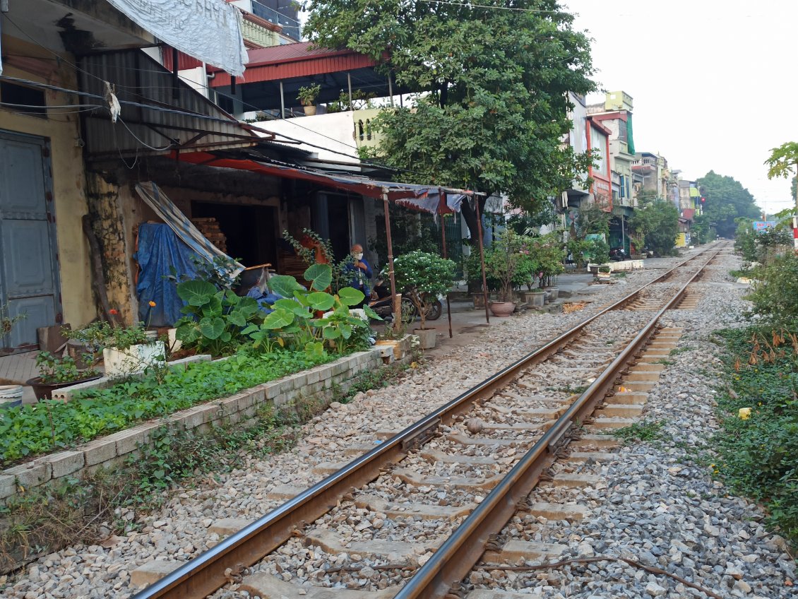 J13. A Hanoi il y a une voie de chemin de fer comme celle-ci qui jouxte maisons et commerces. C'est une attraction touristique très réglementée. Ici personne n'y prête attention.