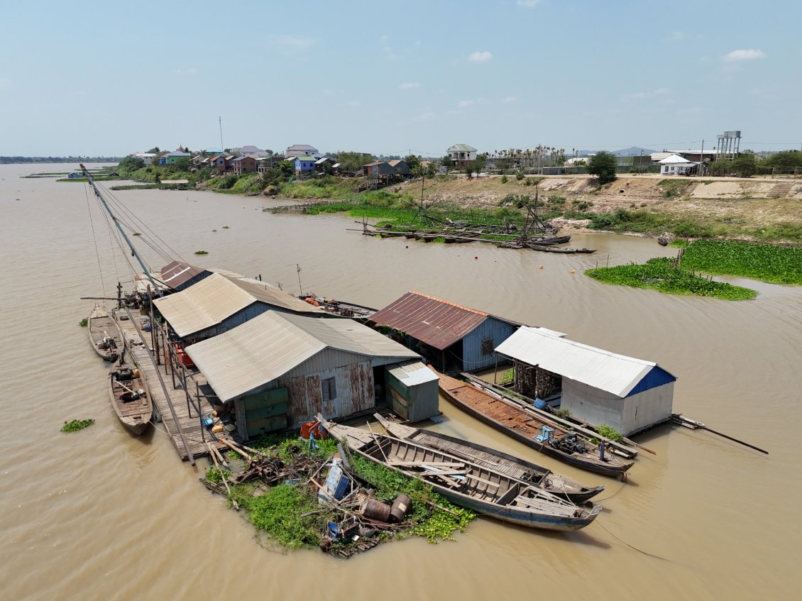 J28. Sur le fleuve il y a plusieurs bâtiments flottants. Certains sont destinés à la pêche, d'autres aux habitations.