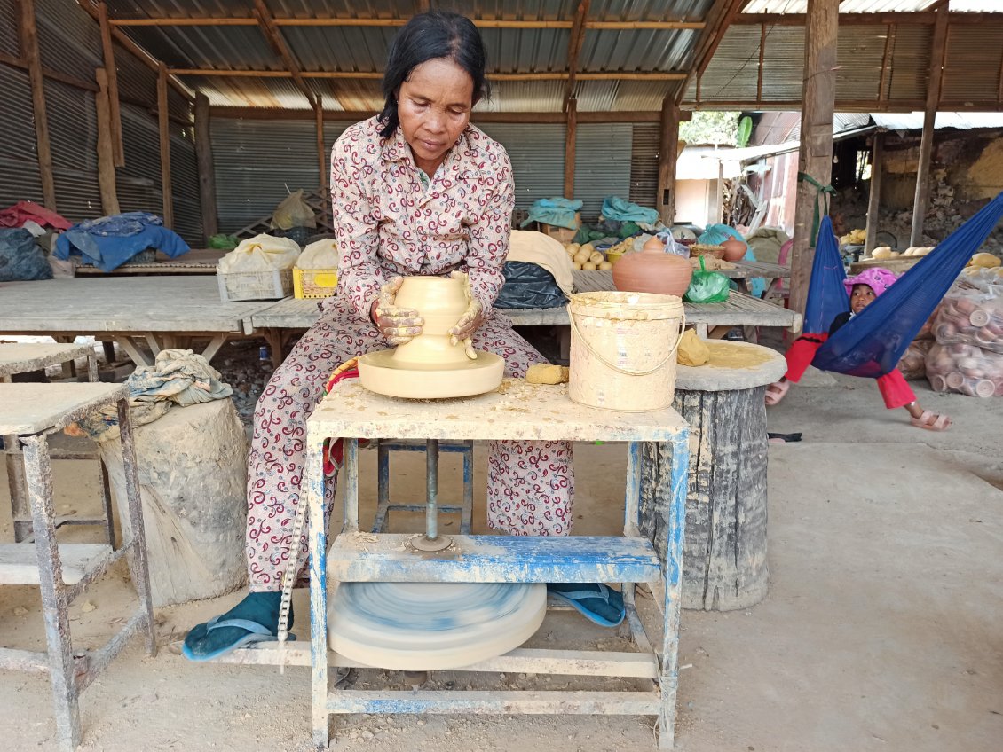 J29. Au village de la poterie Ondong Rossey, dans cette maison, loin du tourisme, la dame a remis son atelier en route pour faire une démonstration. Un moment d'échange prolongé avec la famille car au moment de partir mon pneu était à plat.