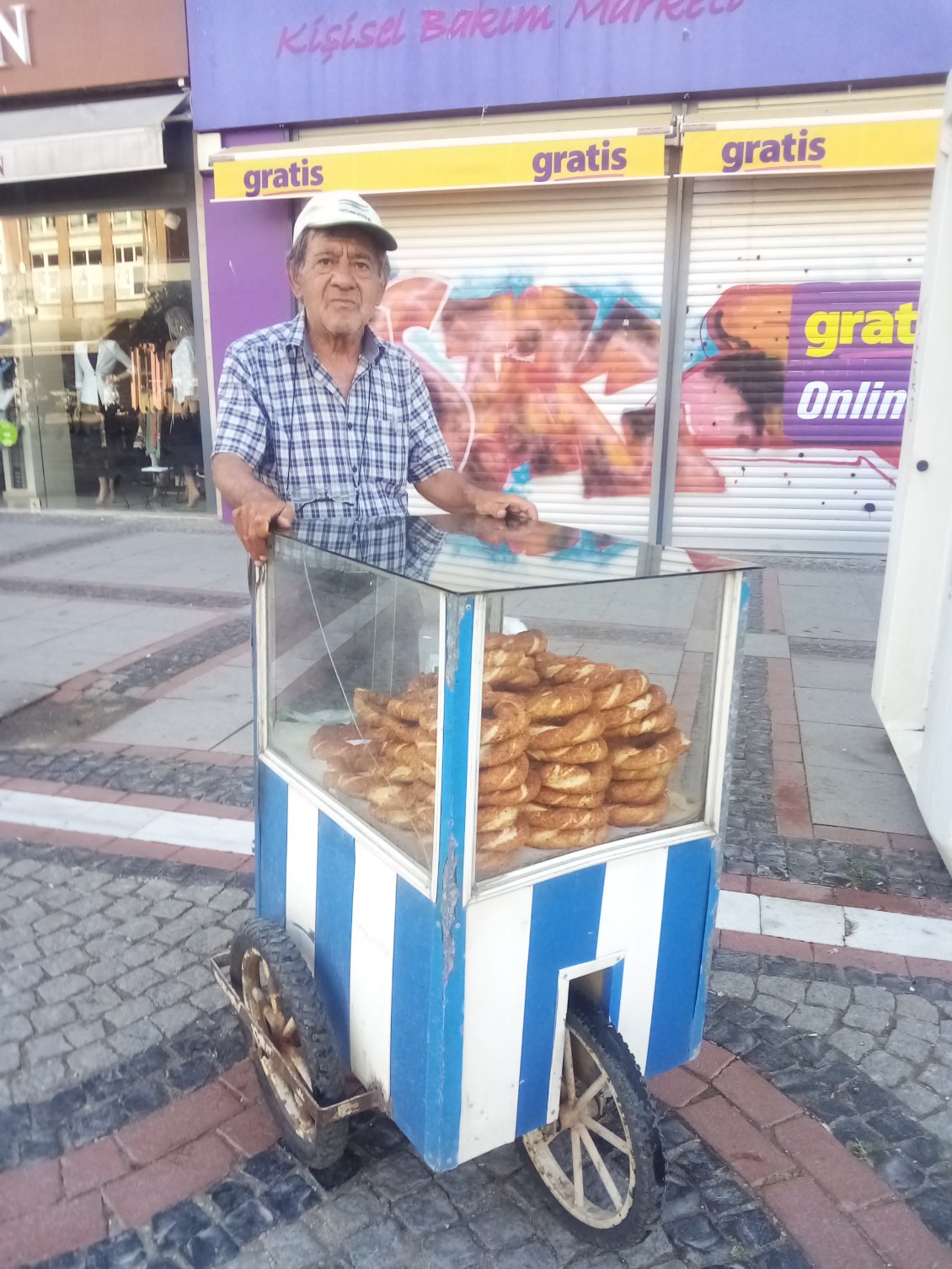 Le monsieur vendeur de Simit et son étalage ambulant.