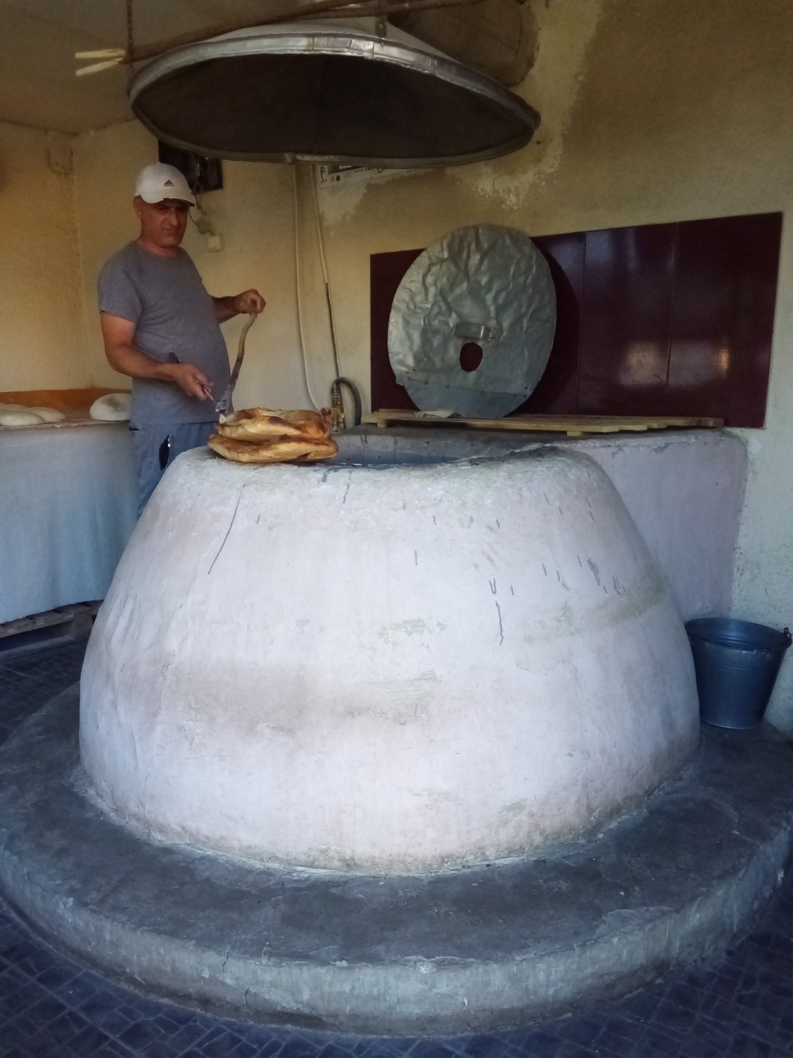 Le boulanger devant son beau four.