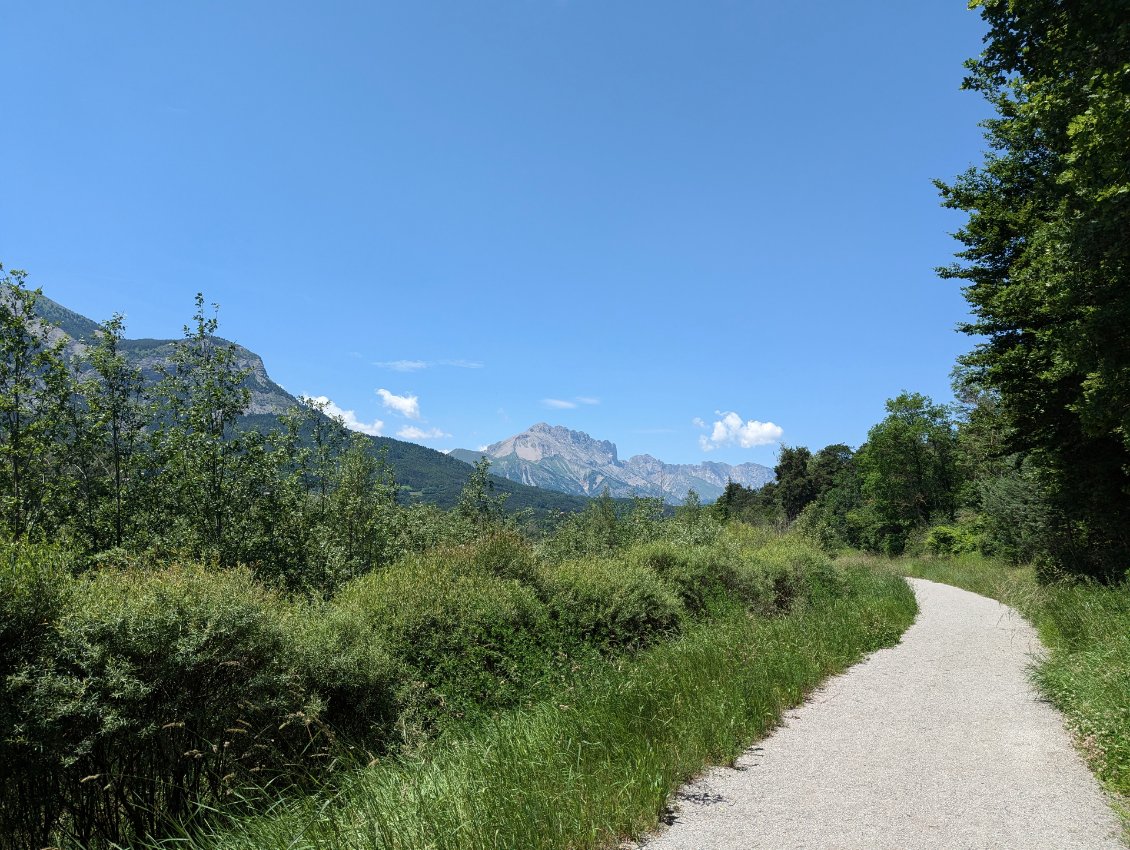 Voie douce le long du Drac, en toile de fond, les faces est de la montagne de Faraut