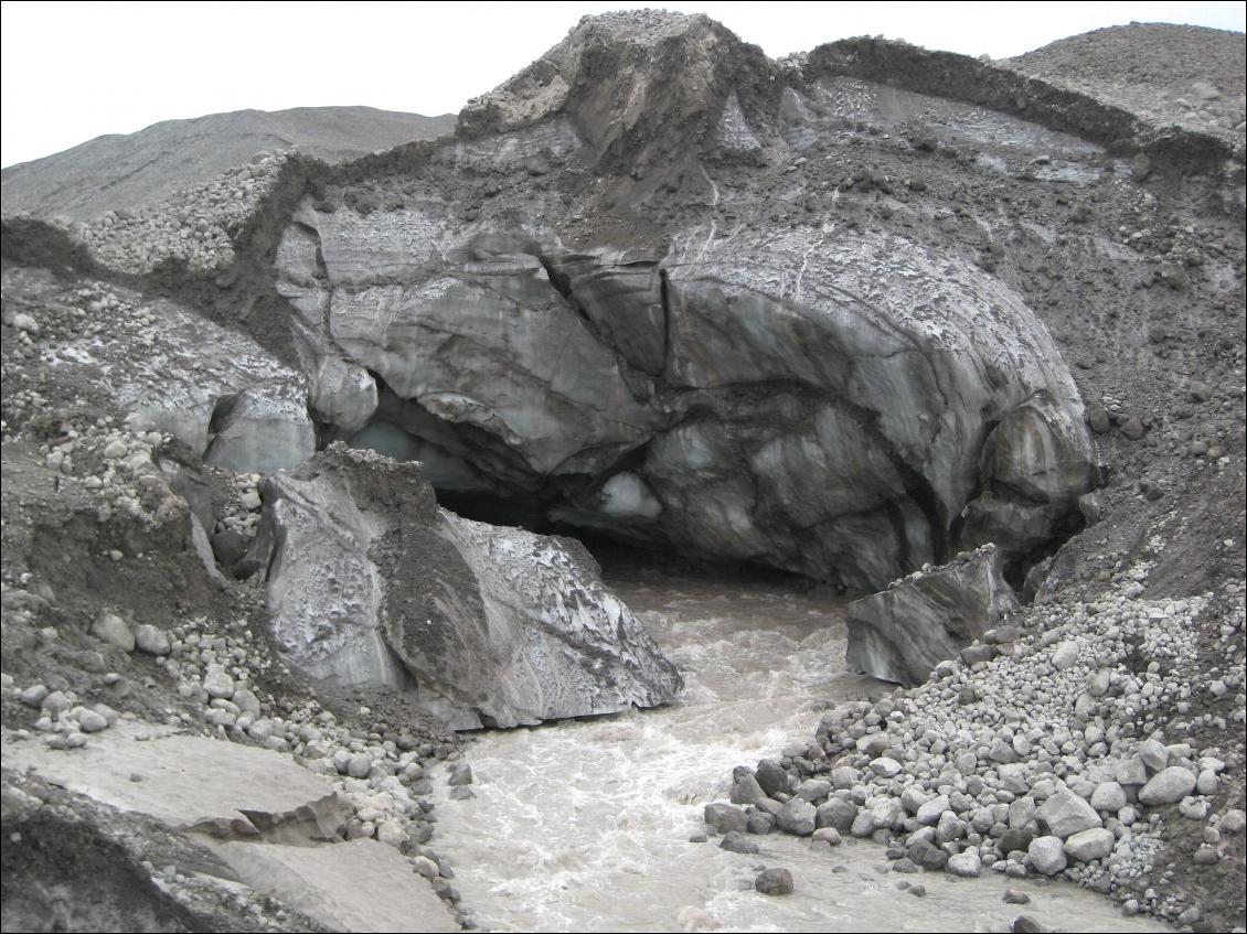 Une rivière sort d'une grotte de glace