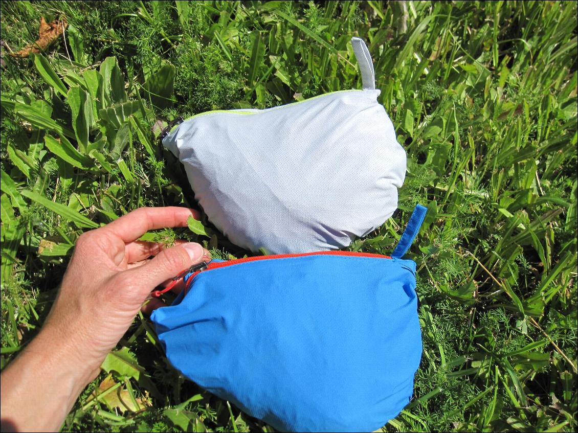 Les Helium Rain rangées dans leur housse (homme en bleu, femme en blanc), on voit l'anneau de tissu qui permet une attache facile au baudrier, au sac à dos, etc.