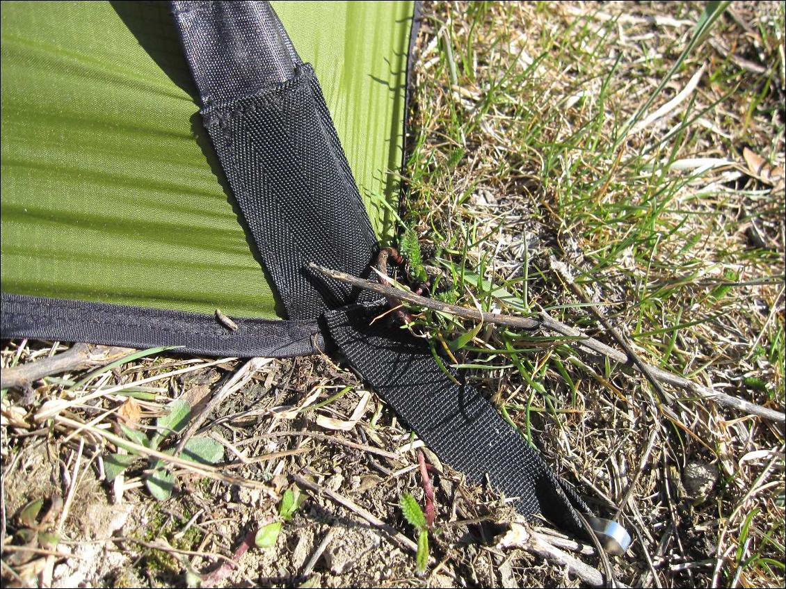 Ici tension du double toit à l'aide d'une boucle de sangle sur sardine